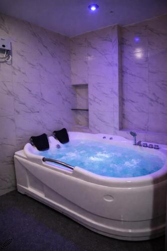 a large bath tub with blue water in a bathroom at Peruyork Arbnb - Calle España in Chiclayo