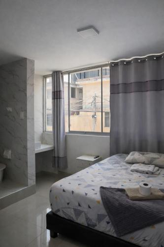 a bedroom with a bed and a large window at Peruyork Arbnb - Calle España in Chiclayo