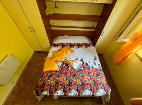 a small room with a bed with a blanket on it at Family Apartment Sofija in Preko