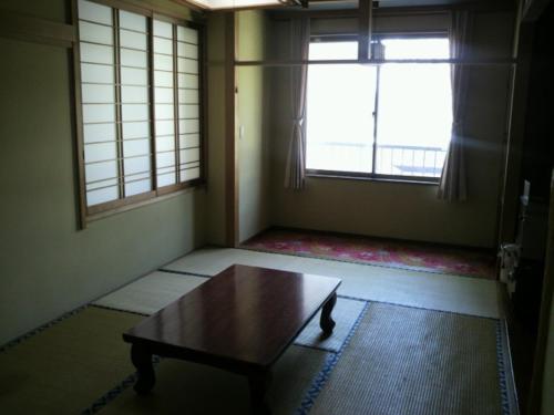 a room with a coffee table and a window at Lodge Ueno Ski in Nozawa Onsen