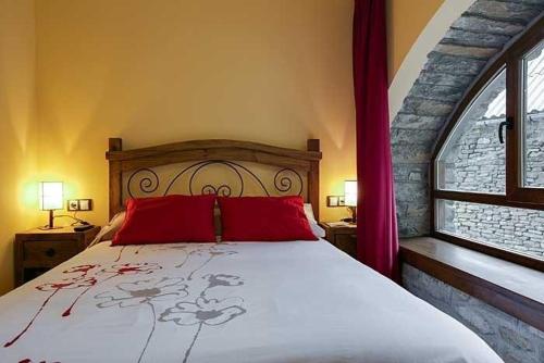 a bedroom with a large bed with red pillows at Casa Rural O Fraginal in Guasillo