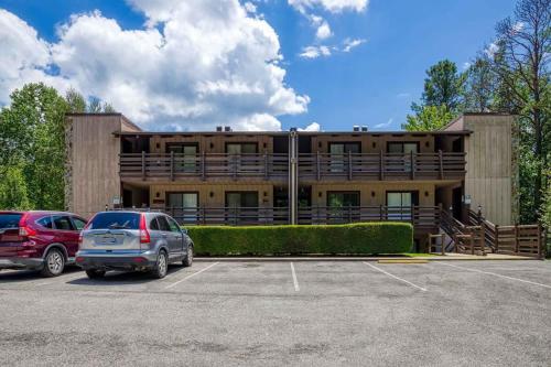 a building with two cars parked in a parking lot at 1023 English Mtn Condo by Beyond Expectations in Sevierville