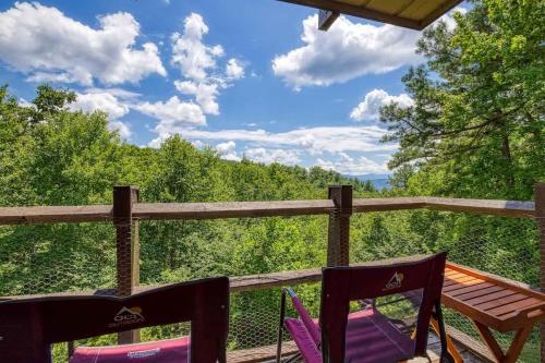 a porch with two chairs and a table with a view at 1023 English Mtn Condo by Beyond Expectations in Sevierville