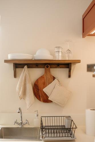 a kitchen with a wooden shelf above a sink at Kamari Guest House Corfu in Corfu International Airport I Kapodistrias