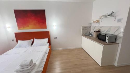 a small bedroom with a bed and a microwave at Aspan City Comfort 3 in Pokrovka