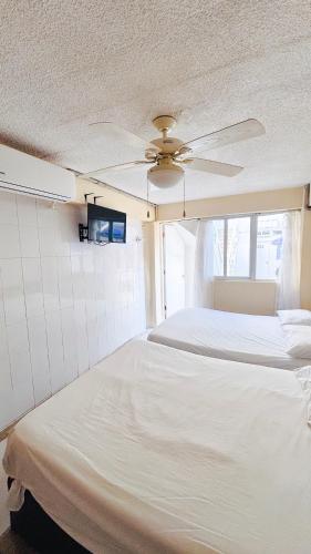 a bedroom with two beds and a ceiling fan at HOTEL PARAISO ACAPULCO in Acapulco