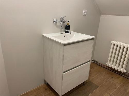 a white bathroom sink with a bottle of wine on it at Penzion Vejprty in Vejprty