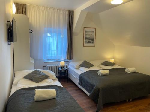 two beds in a small room with a window at Penzion Vejprty in Vejprty