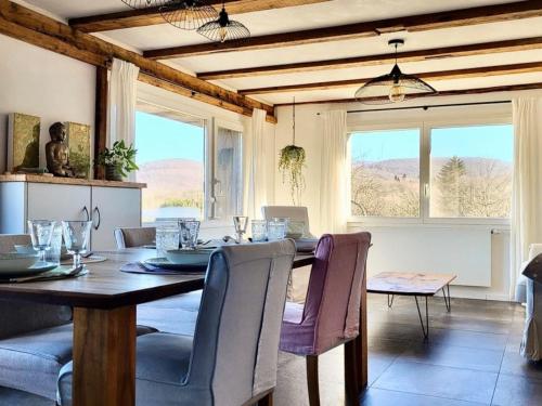 a dining room with a table and chairs and windows at Cœurvert Nature Silence, Panorama - Ronchamp & Le Corbusier in Ronchamp