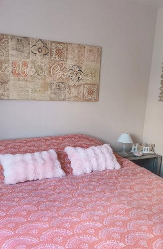 a bedroom with a bed with two pillows on it at Chambre la Bohème in Élancourt