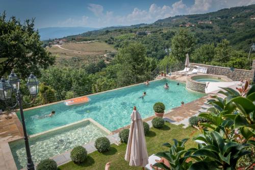 a large swimming pool with people in the water at Borgo dei Gigli in Lamporecchio