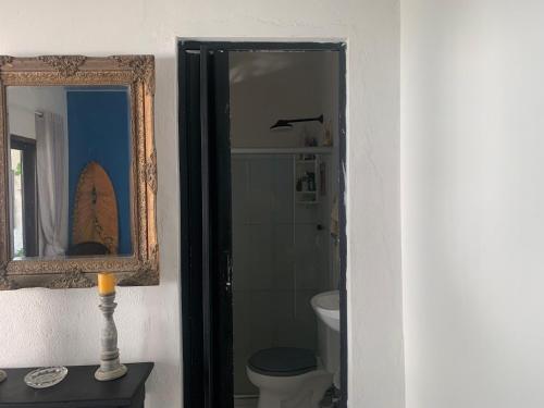 a bathroom with a toilet and a mirror at casa aconchegante proximo a praia in Maceió