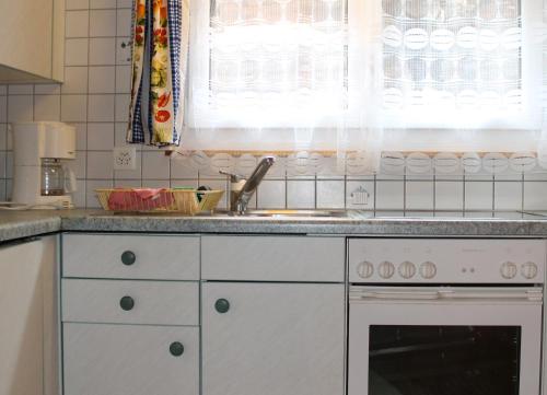 Una encimera de cocina con un fregadero y un fregadero. en Chalet Alpentraum, alte Gasse 20, en Saas-Grund