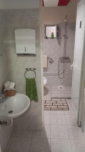 a bathroom with a sink and a shower and a toilet at House Marios airport 3 in Spata