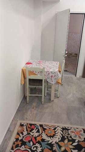 a table and chair with a table and a rug at House Marios airport 3 in Spata