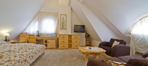 a living room with a bed and a tv at Willa Kominiarski Wierch in Zakopane