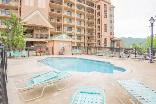 a swimming pool with lounge chairs and a hotel at Gatehouse Condo by Beyond Expectations w Views in Gatlinburg