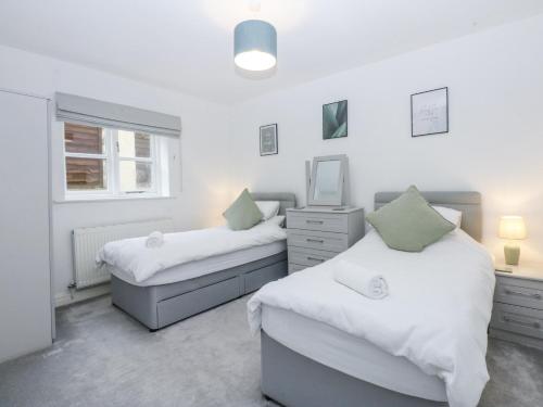 a bedroom with two beds and a mirror at Capel Y Ffynnon in Llandudno Junction