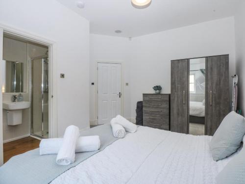 a white bedroom with a large bed with towels at Capel Y Ffynnon in Llandudno Junction