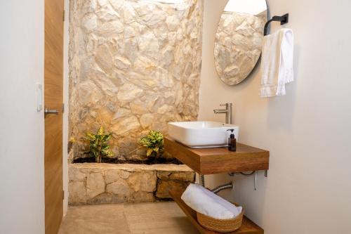 a bathroom with a sink and a stone wall at Gardin Home in Cali
