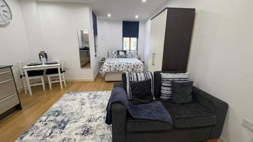 a living room with a couch and a bed at Chic Studio near Canary Wharf in London