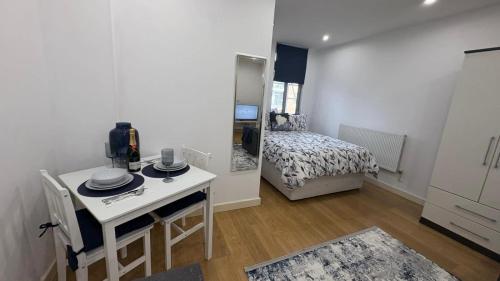 a room with a table and a bedroom with a bed at Chic Studio near Canary Wharf in London