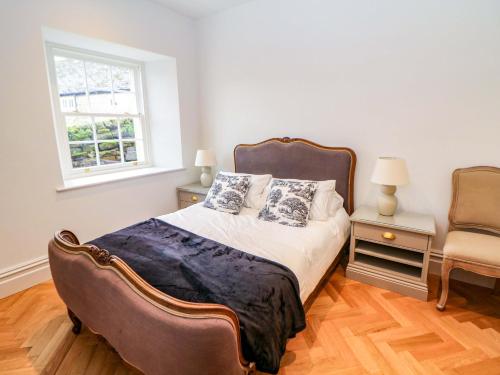 a bedroom with a bed and a window and a chair at The Reading Room in Grindleford Bridge