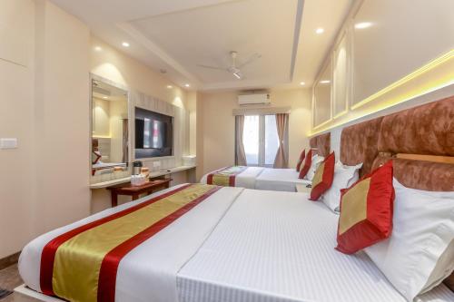a bedroom with a large bed and a television at Avtar new delhi railway station in New Delhi