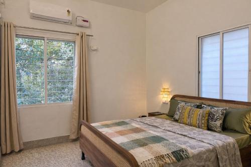 a bedroom with a bed and a window at Ardor Homestay in Jabalpur