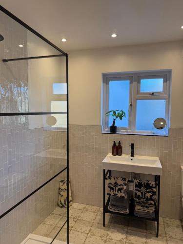 a bathroom with a sink and a shower at 5 Bed Cottage in Enfield