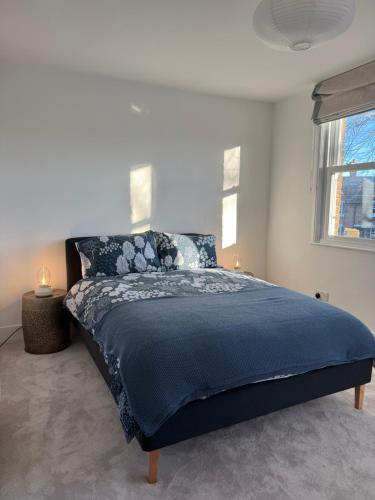a bedroom with a large bed with a blue comforter at 5 Bed Cottage in Enfield