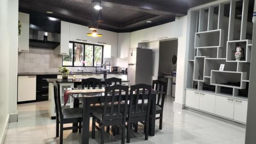 a kitchen with a dining room table and chairs at Zosang Homestay in Āīzawl