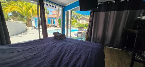 a bedroom with a purple bed with a view of a pool at Studio proche de l'Océan - Calme et Pratique in Capbreton