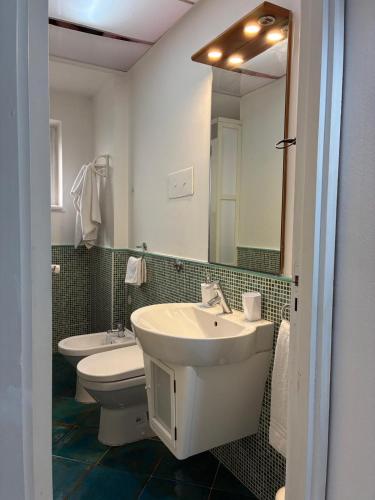 a bathroom with a sink and a toilet and a mirror at Sara House Palermo in Palermo