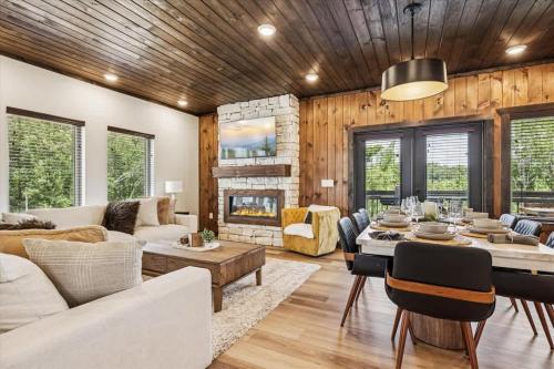 a living room with a table and a fireplace at Peak Pursuit by Beyond Expectations w Indoor Pool in Pigeon Forge