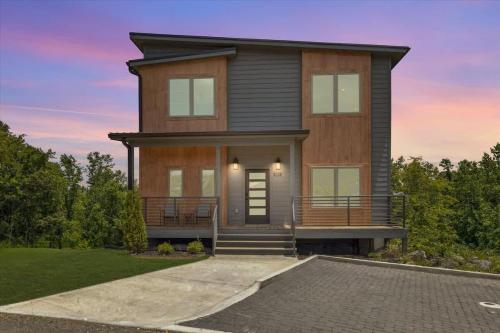 a large wooden house with a front porch at Peak Pursuit by Beyond Expectations w Indoor Pool in Pigeon Forge