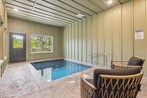 a swimming pool in a room with two chairs at Peak Pursuit by Beyond Expectations w Indoor Pool in Pigeon Forge