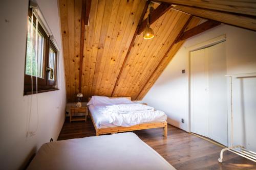 a bedroom with a bed and a wooden ceiling at Domek Umilenia in Mrzygłód