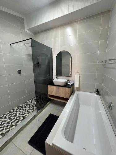 a bathroom with a tub and a sink at Stay at Tzaneen in Tzaneen
