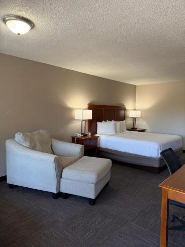 a hotel room with two beds and a chair at Great Smokies Inn - Cherokee in Cherokee