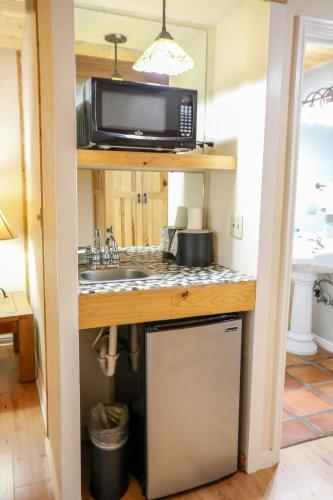 a kitchen with a sink and a microwave at The Boulder Creek Lodge in Nederland
