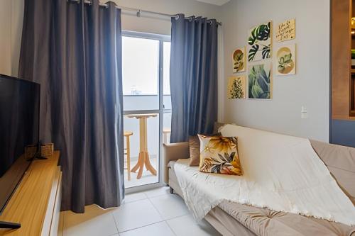 a living room with a couch and a television at Curta Praia do Quilombo - Lunata in Penha