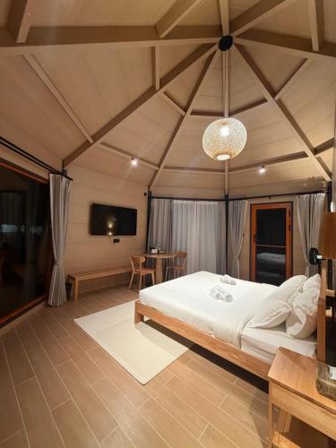 a bedroom with a large white bed and a tv at Pudina Resort in Semporna