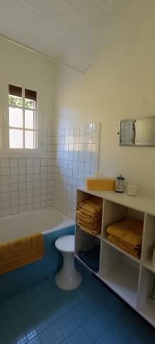 a bathroom with a bed and a toilet in it at Le Village Champignon in Aspet