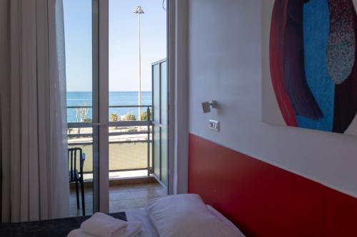 a room with a bed and a view of the ocean at Delfini Hotel in Patra