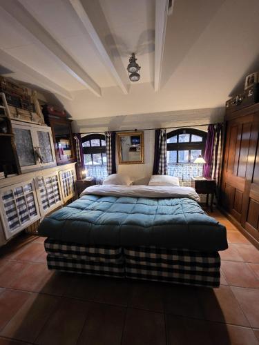 a bedroom with a large bed in a room with windows at Op Vakantie bij Nicole in Putten