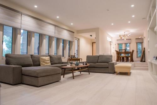 a living room with two couches and a table at THALIA, luxury 3Br Home with Ensuite Bathrooms, just 3 minutes walk from the beach located in the prestigious Athenian Riviera in Athens
