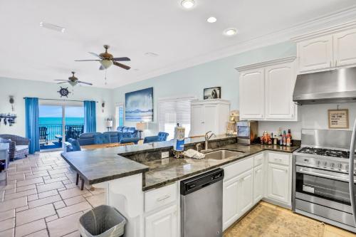 a kitchen and living room with a view of the ocean at Beachfront home with pool elevator dog-friendly in St. George Island