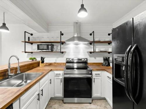 a kitchen with white cabinets and a black refrigerator at Turkey Nest by Beyond Expectations Renovated 2BR in Gatlinburg