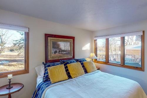 a bedroom with a bed and two windows at Work & Play! Spacious Lake-View Home in Greeley in Greeley